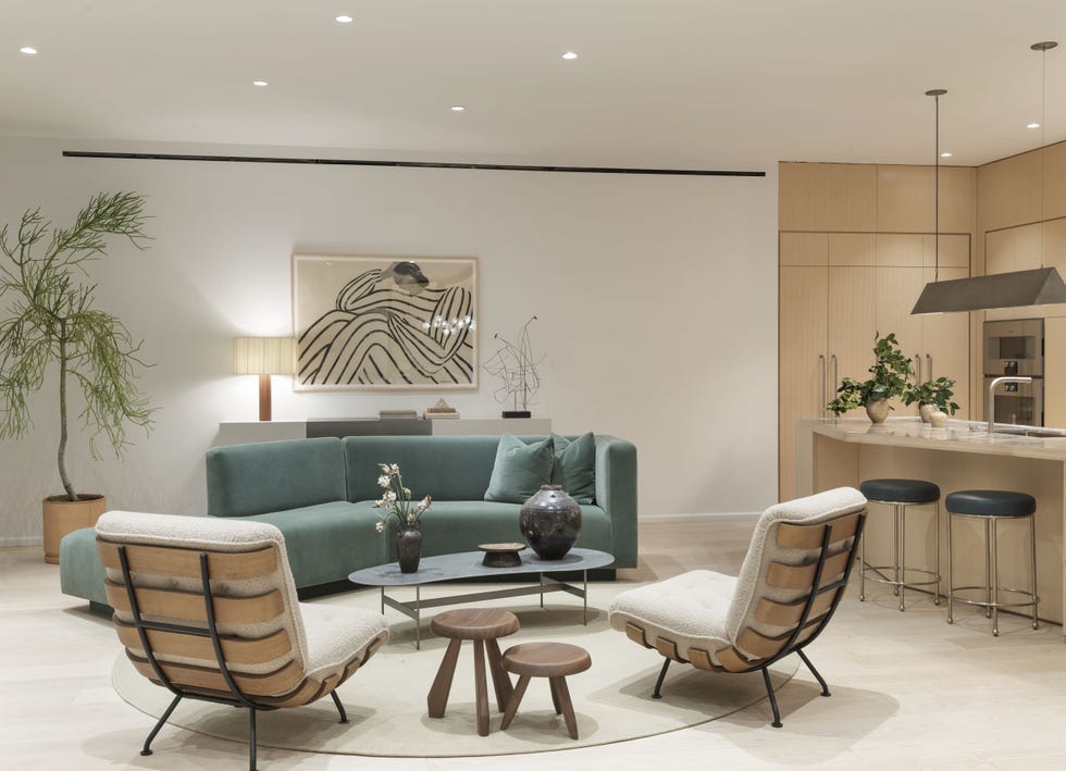 cocina y salón de diseño moderno con sofá de terciopelo verde y dos butacas lounge