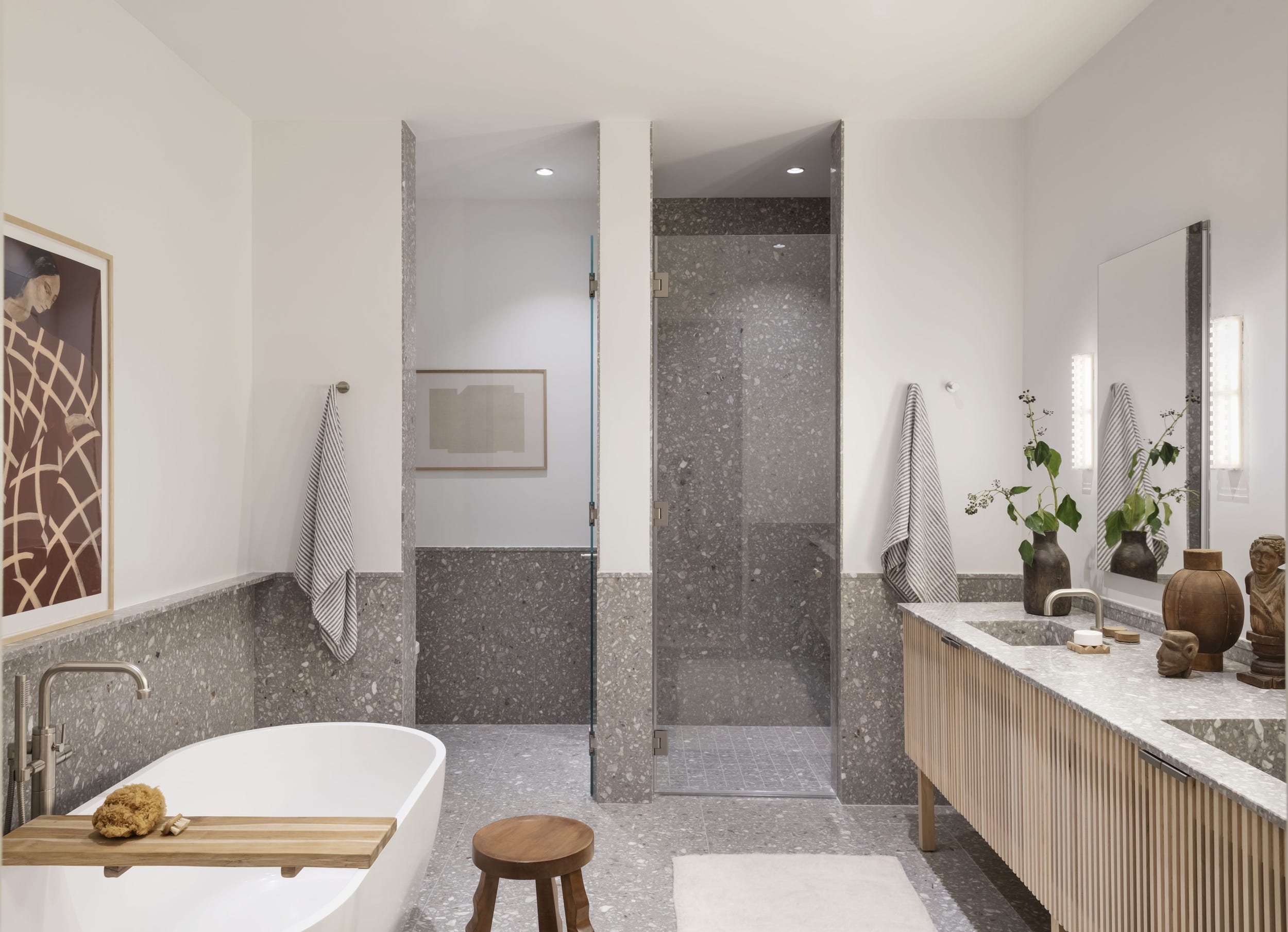 baño moderno doble revestido con terrazo gris y bañera exenta