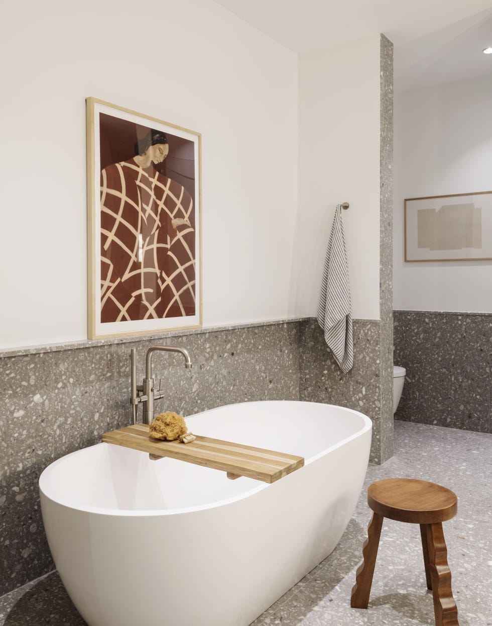 baño moderno revestido con terrazo gris y bañera exenta