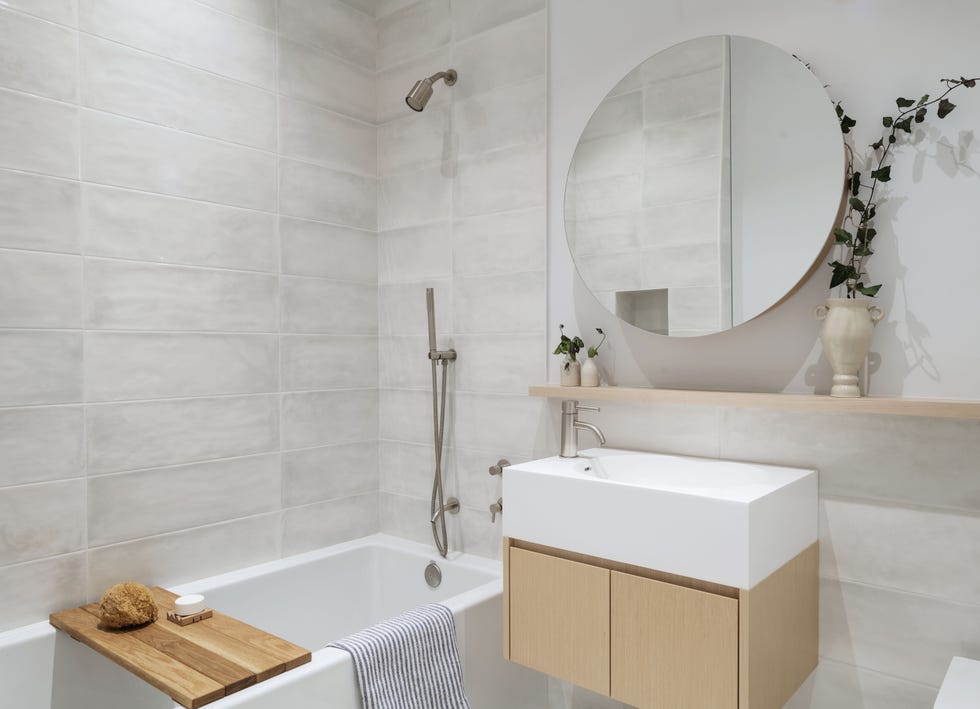 baño con bañera y mueble de madera suspendido