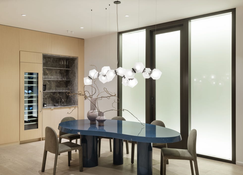 comedor de diseño moderno con mesa azul y lámparas suspendidas blancas
