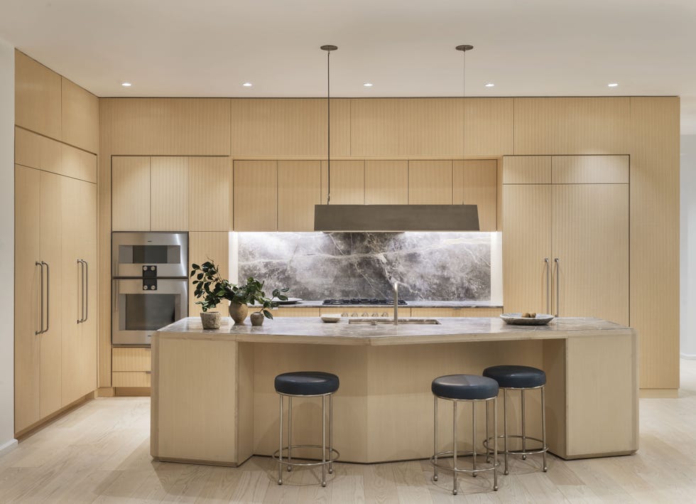 cocina de madera con isla central y frente de mármol