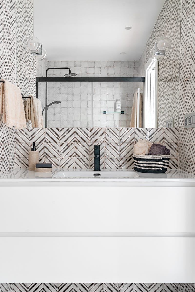 baño moderno con mueble suspendido y azulejos geométricos