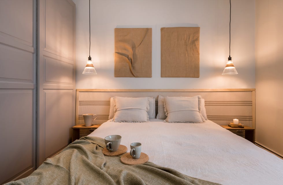 dormitorio con cabecero de madera y tela y armario gris con puertas correderas
