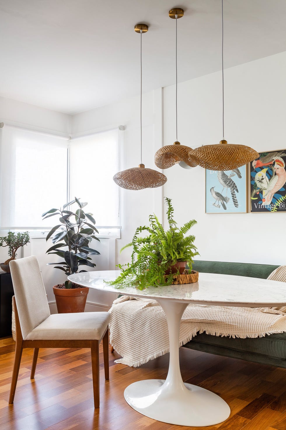 mesa tulip con sobre de mármol, sofá tapizado en verde y sillas tapizadas en beige