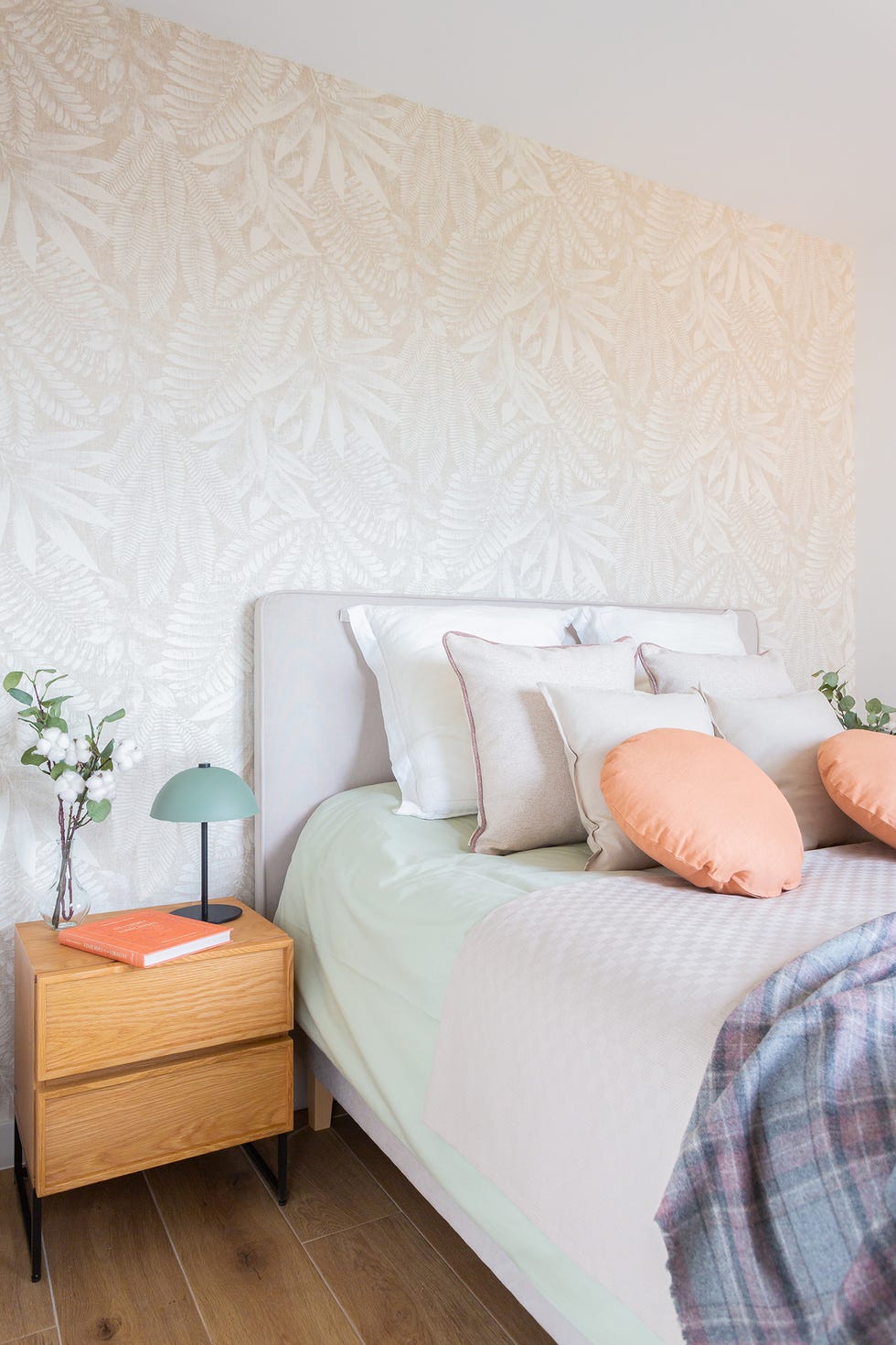 dormitorio con papel pintado con motivos botánicos beige y cabecero a juego