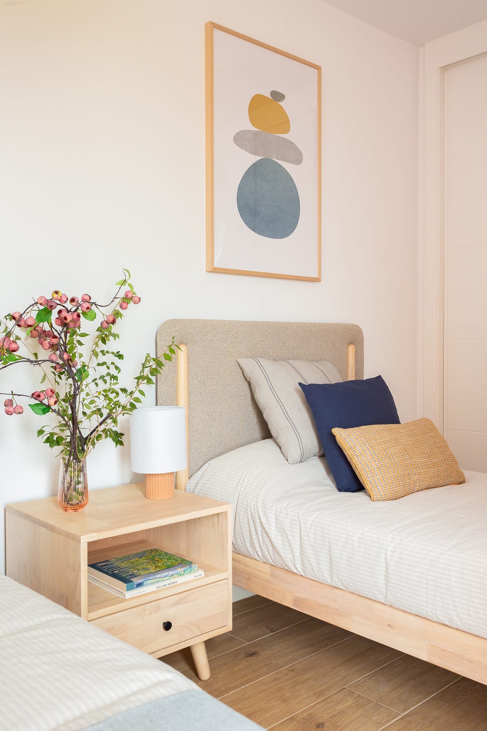 habitación con dos camas de madera con cabeceros tapizados en beige