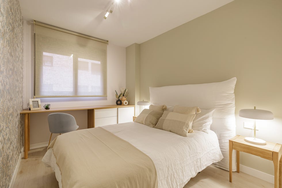 dormitorio con cabecero de lino y escritorio en blanco y madera