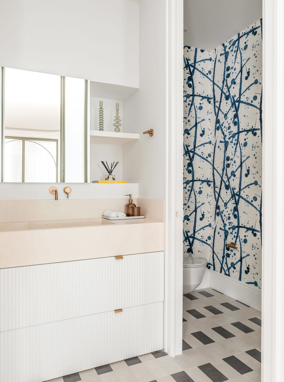 mueble de baño con encimera de mármol y pared del sanitario con papel pintado con motivos azules