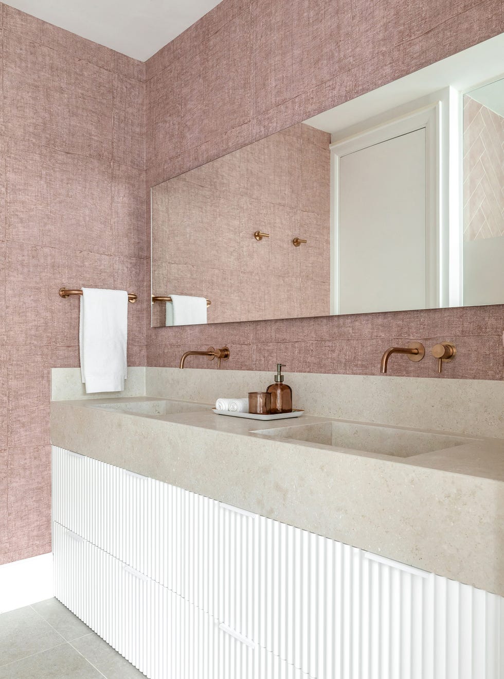 baño con mueble de hormigón y paredes con papel pintado rosa