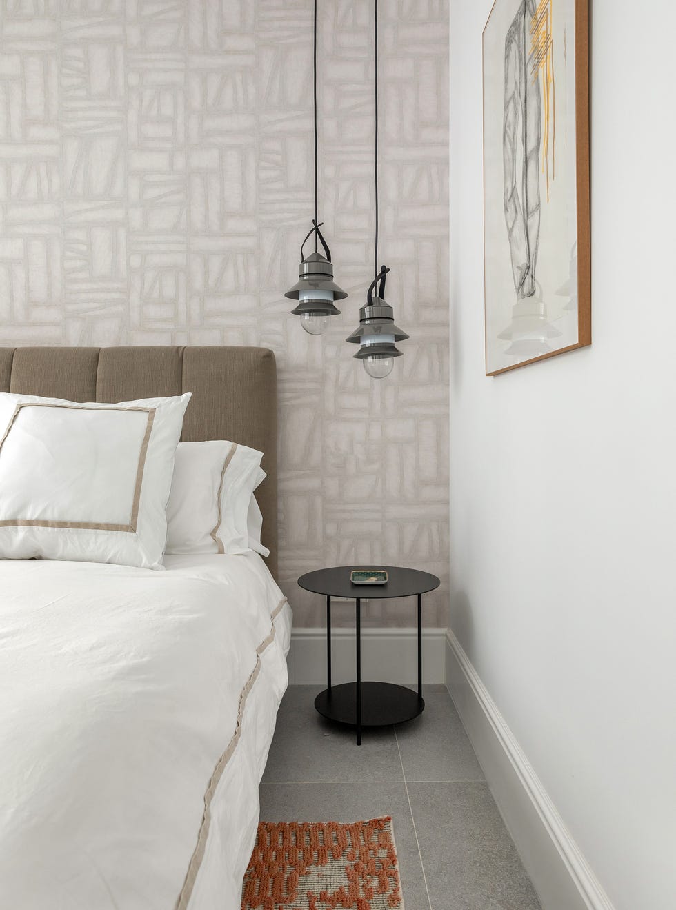 cama con cabecero acolchado marrón y papel pintado con motivos abstractos
