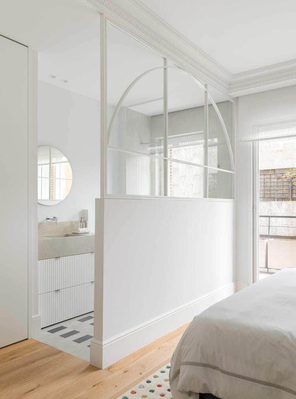 dormitorio con baño en suite tras un murete