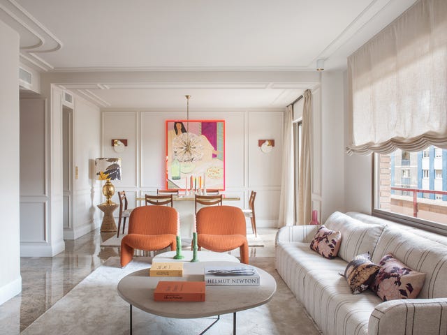 salón comedor con molduras y butacas naranjas de diseño contemporáneo