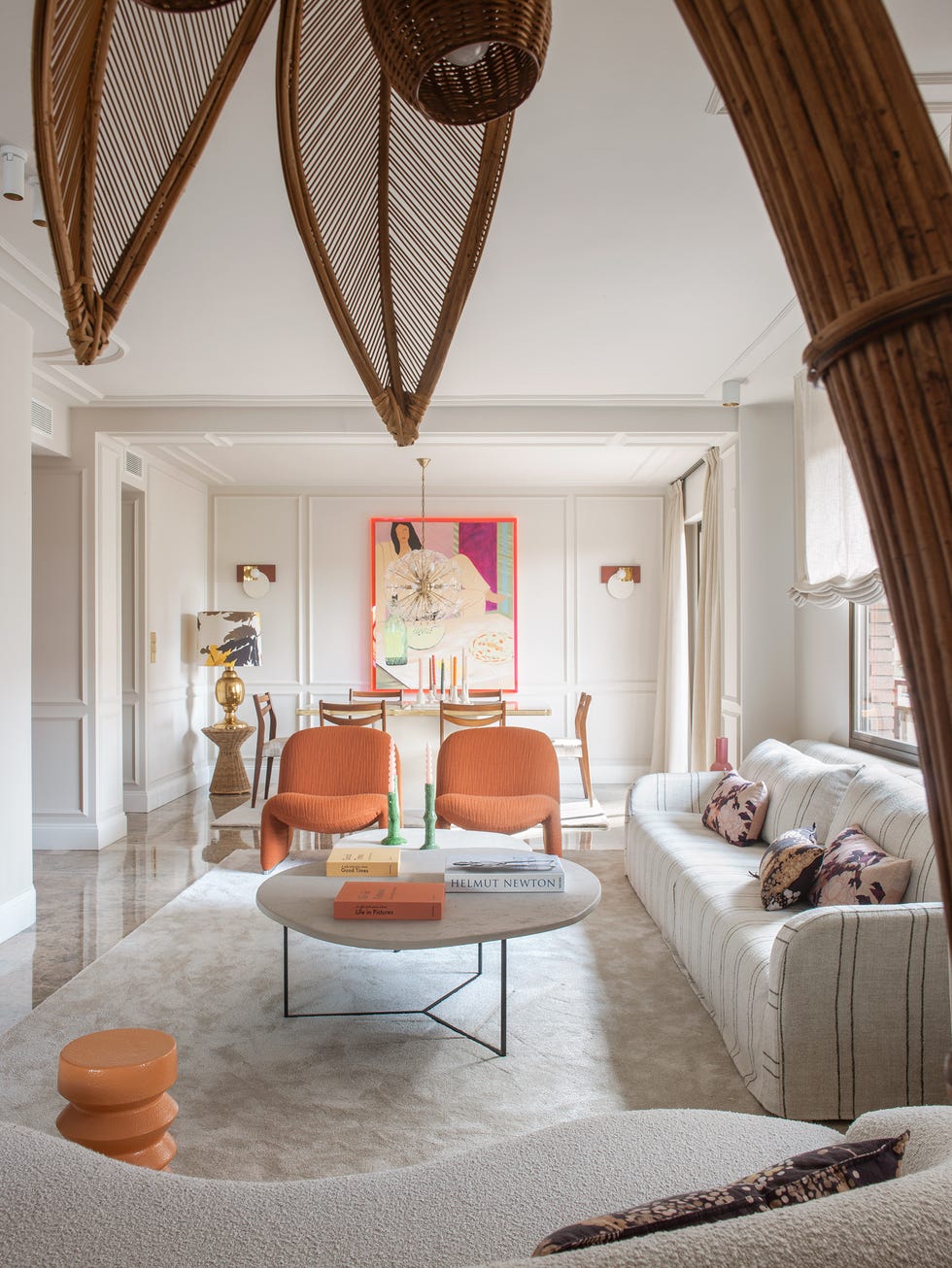 salón con butacas naranjas, mesa de centro con forma orgánica y sofás