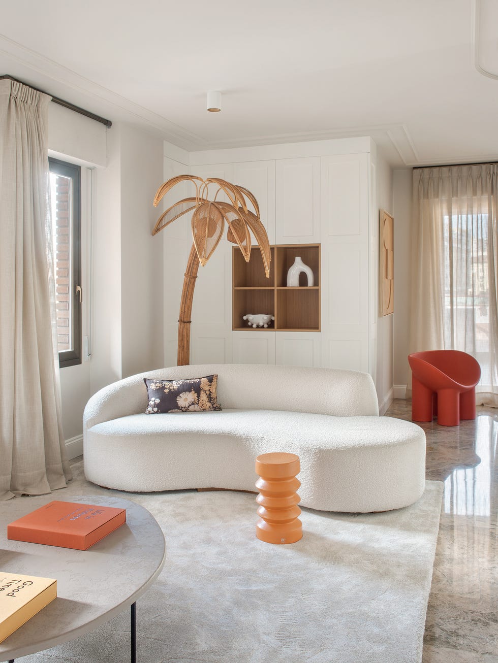 sofá curvo blanco y lámpara en forma de palmera