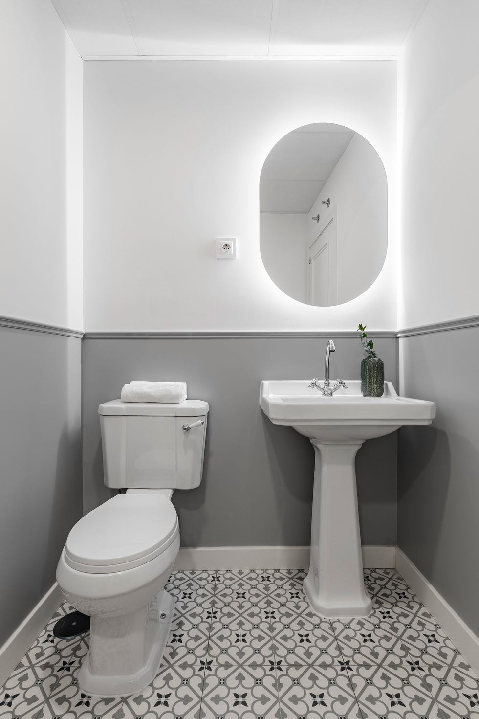 baño con arrimadero gris y suelo de baldosas hidráulicas