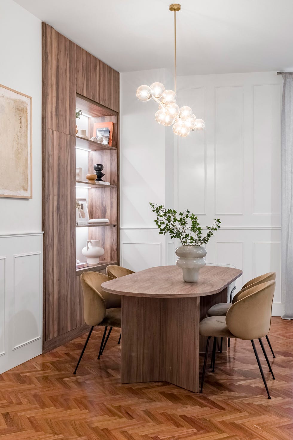 mesa de comedor de madera ovalada, sillas y lámpara suspendida con bolas de cristal
