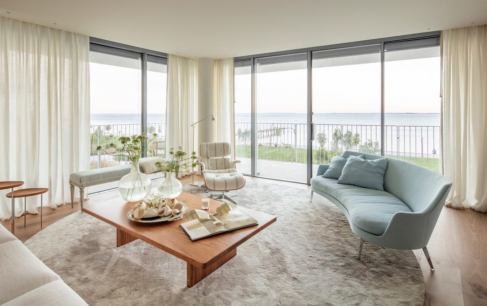 salón con sofá curvo azul y mesa de centro de madera