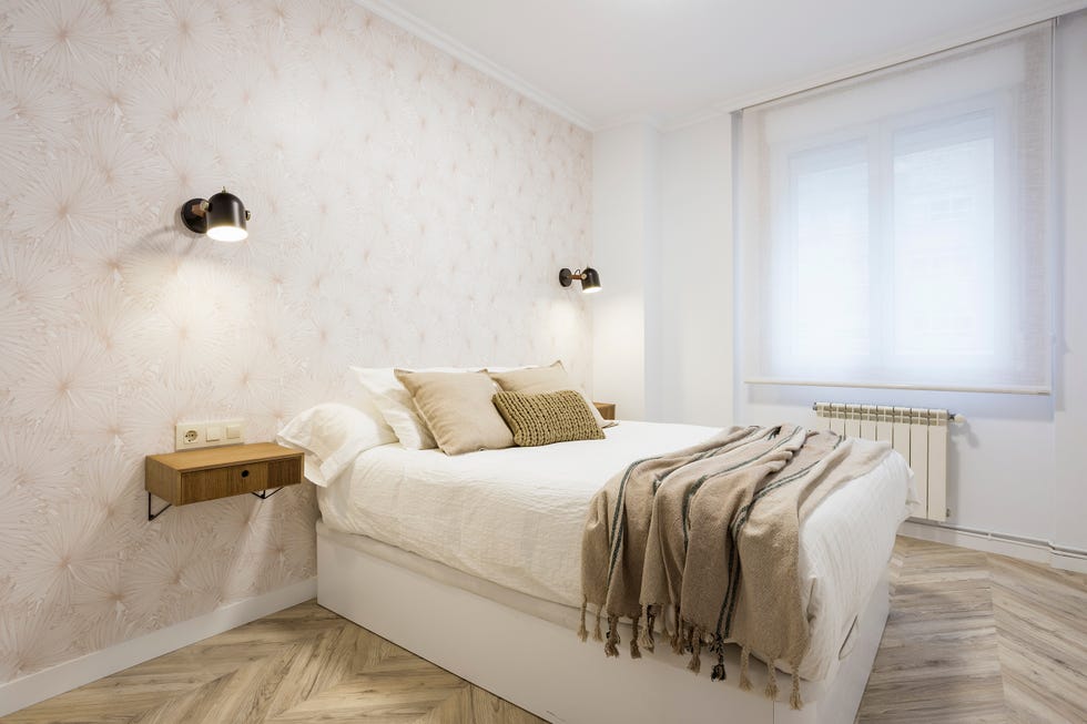 dormitorio con papel pintado con motivos geométricos y apliques negros