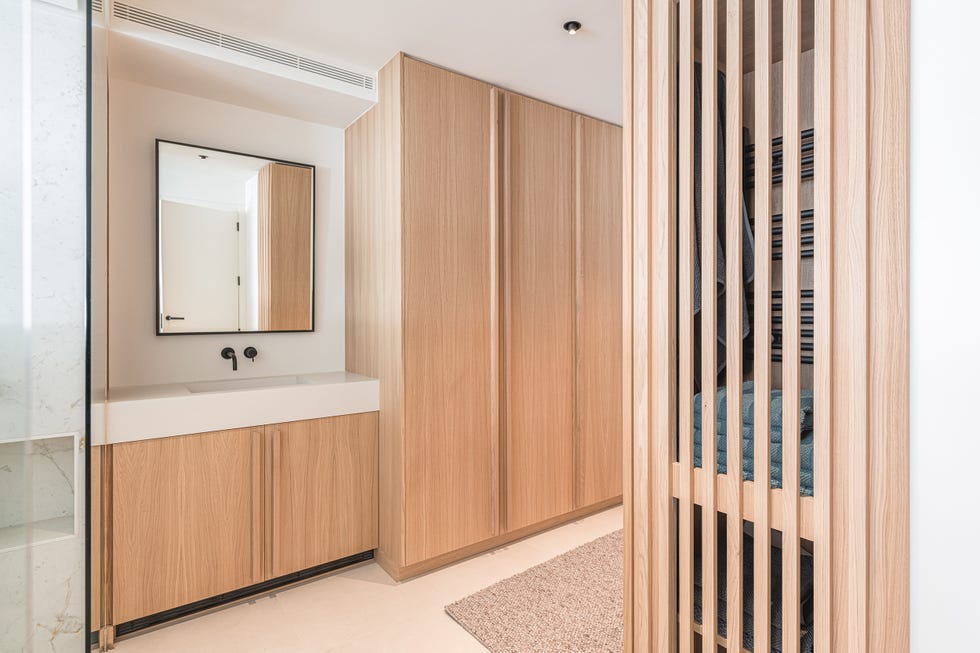 baño con ducha y muebles de roble