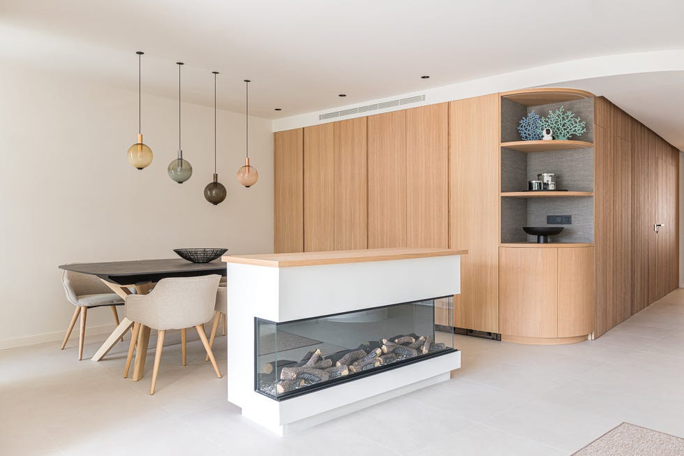 zona de comedor con chimenea y armario de madera de roble