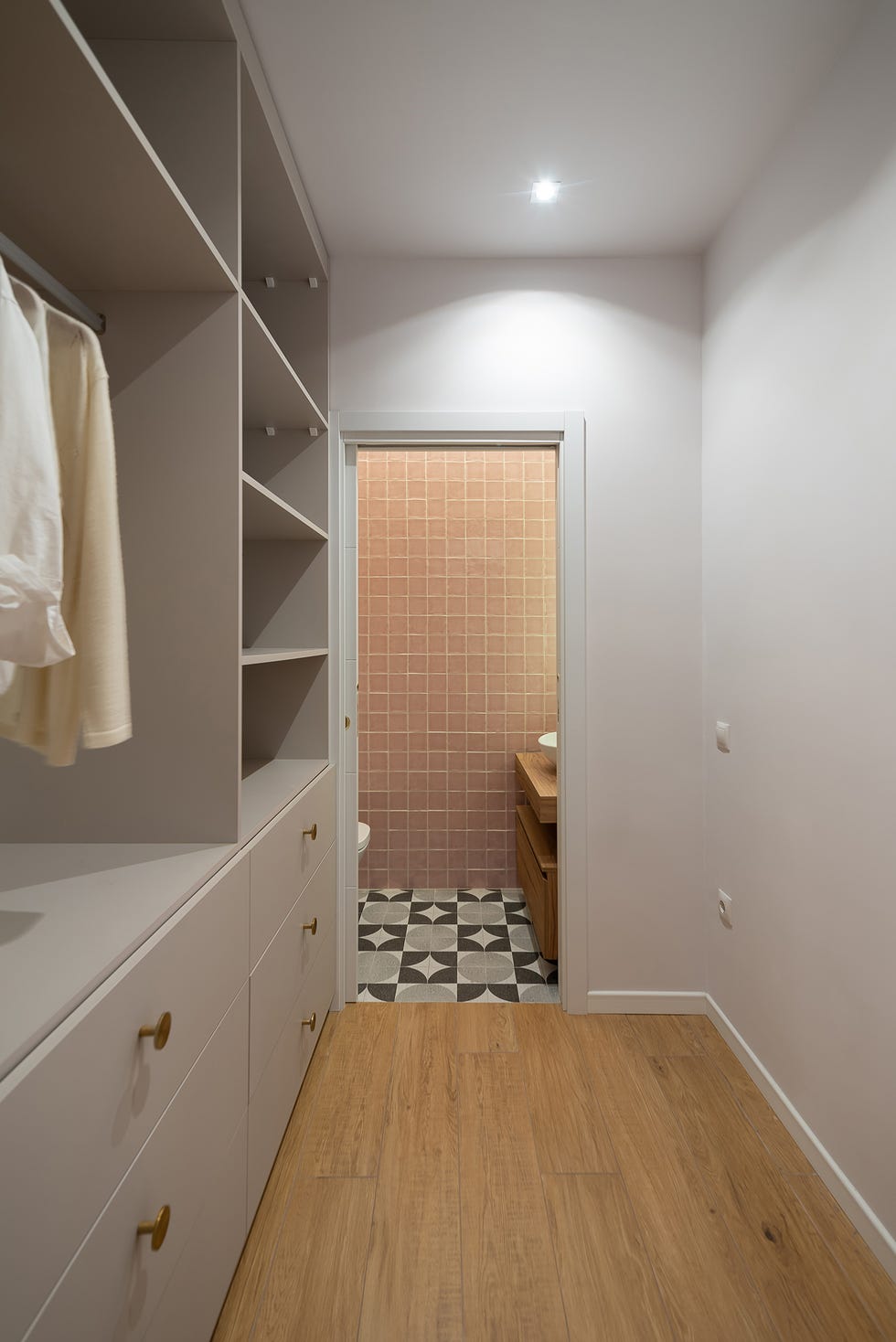 vestidor con armario empotrado gris y acceso al baño