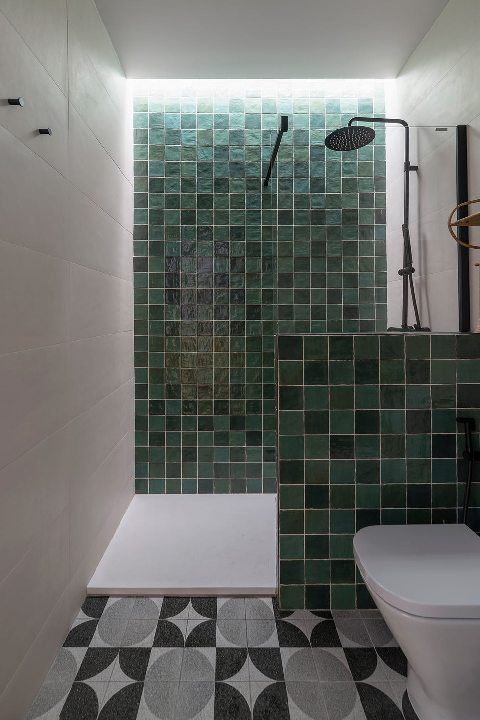 baño de estilo retro con ducha y azulejos verdes en las paredes