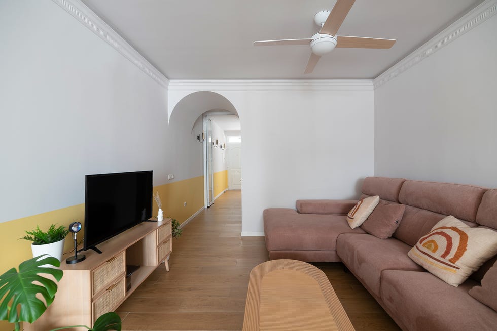 salón con sofá con chaise longue rosa y mueble de tv de cannage