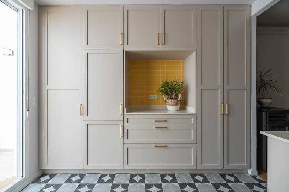 cocina de esrtilo mid century con armario empotrado gris y suelo con baldosas geométricas