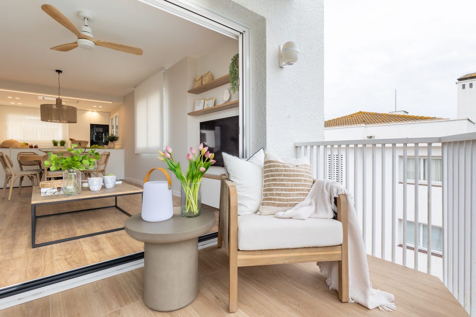 terraza con butaca de madera y mesa auxiliar
