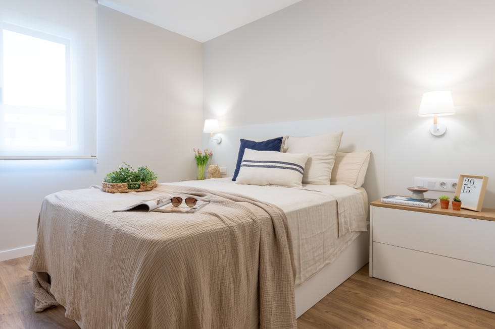 dormitorio con cabecero y mesita de noche en blanco
