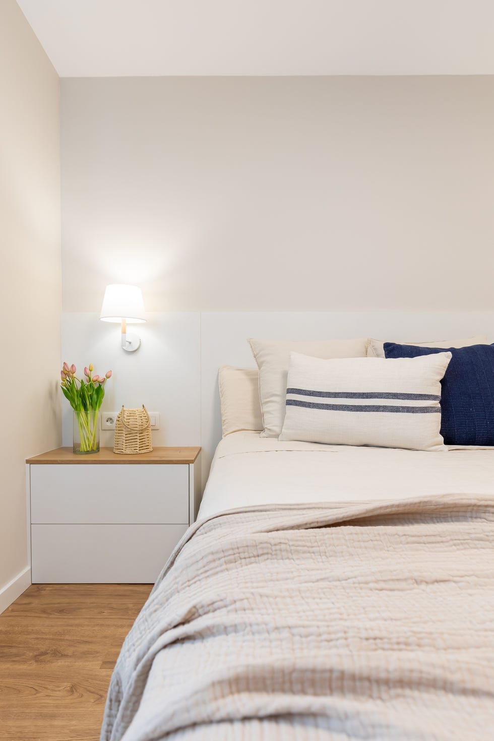 dormitorio con cabecero y mesita de noche en blanco