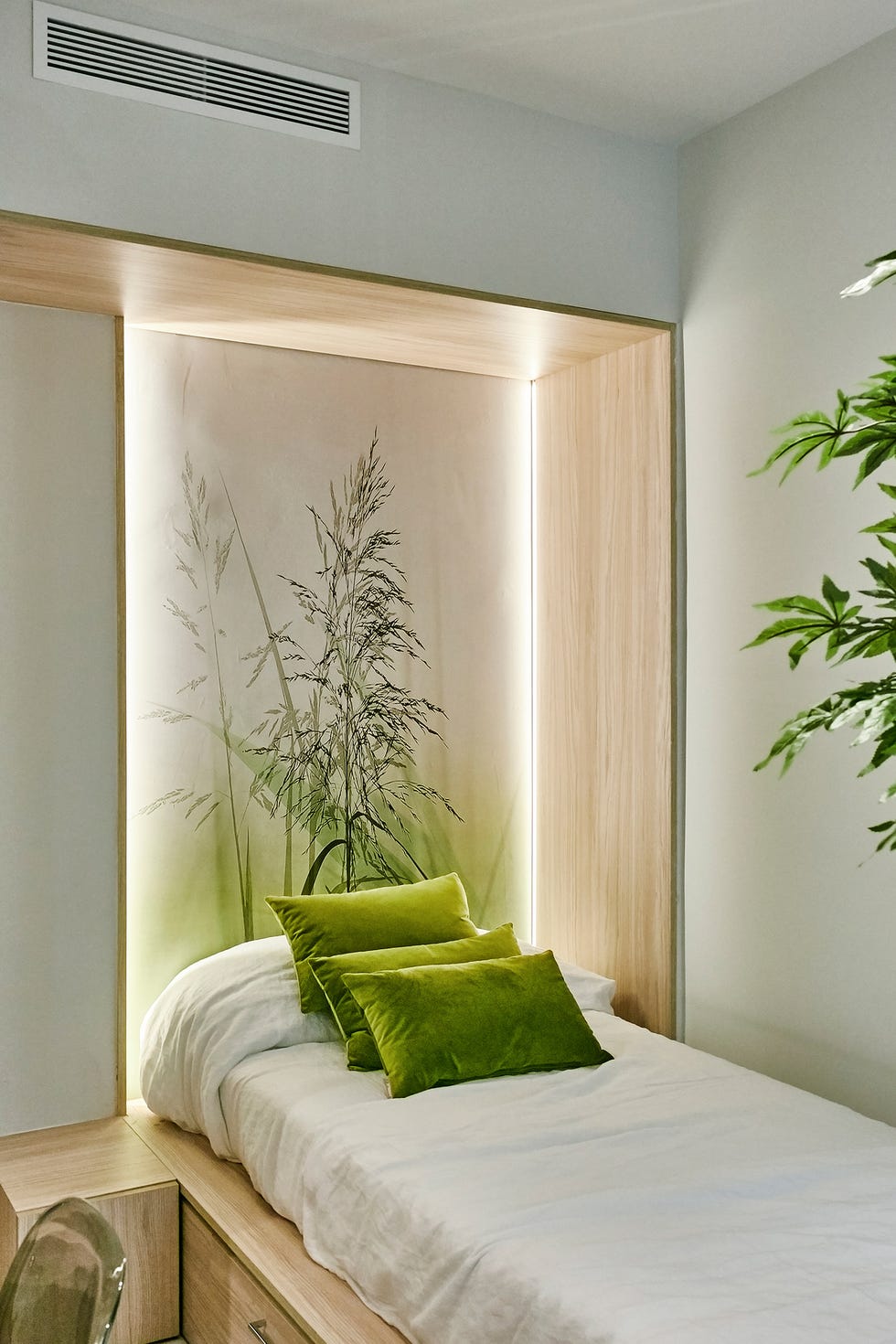 dormitorio con cabecero de madera retroiluminado y papel pintado botánico