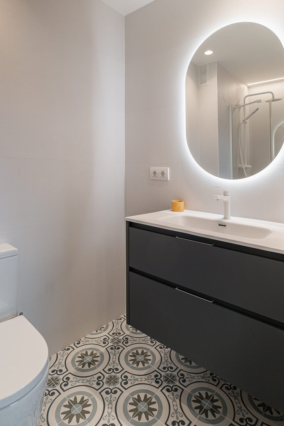 baño con mueble volado y suelo hidráulico