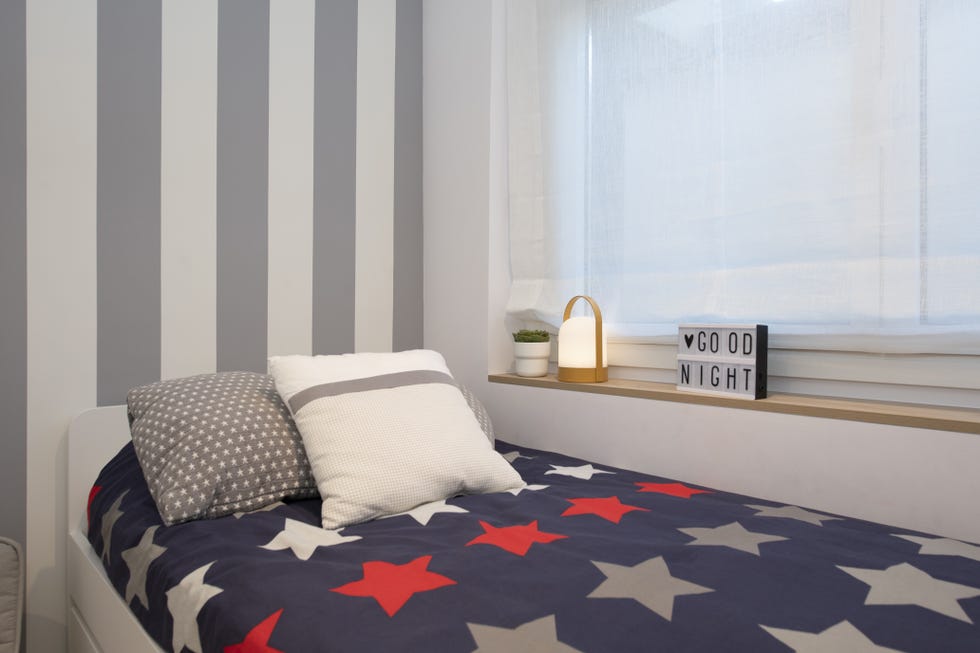 habitación infantil con cama nido blanca y papel pintado a rayas