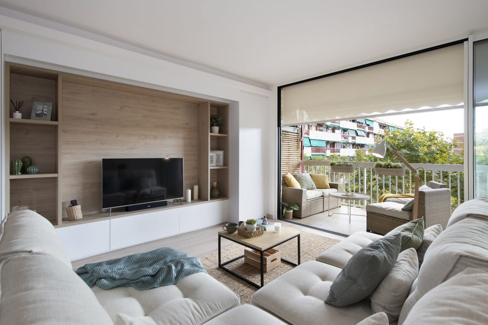 salón de diseño nórdico con sofá rinconera modular, mesa de centro de madera y acero y alfombra de fibras