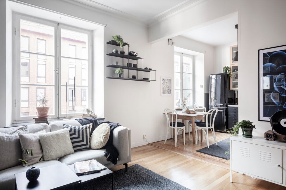 salón de estilo nórdico decorado en blanco y azul abierto a la cocina