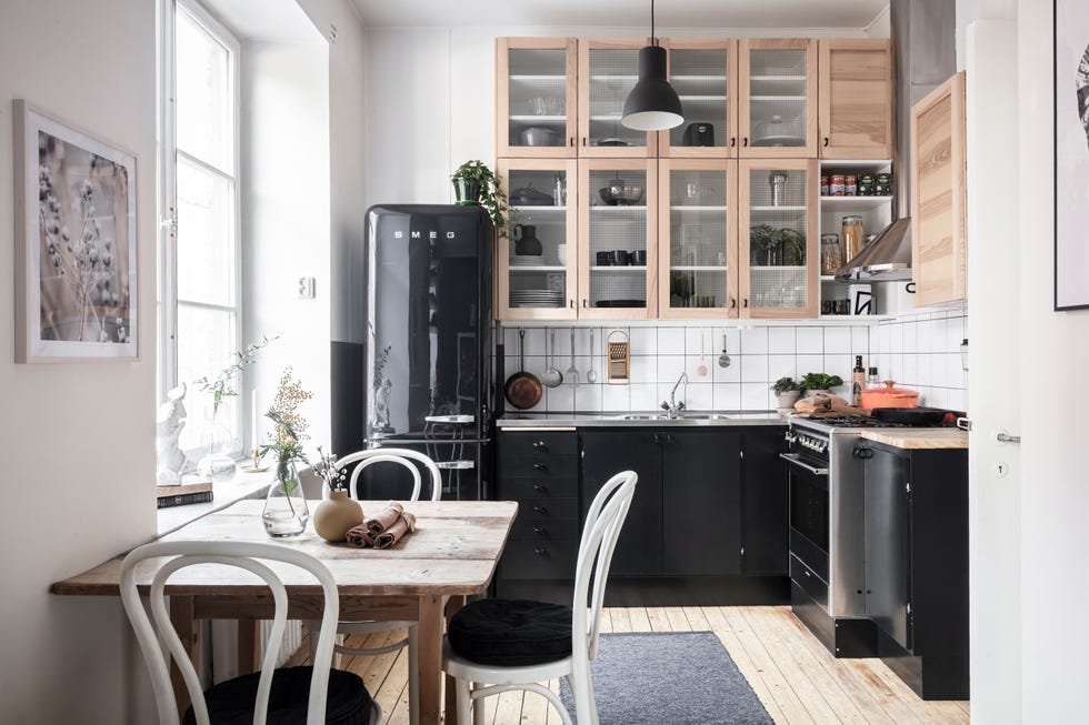 cocina abierta con office de estilo nórdico decorada en blanco con electrodomésticos y armarios de color negro