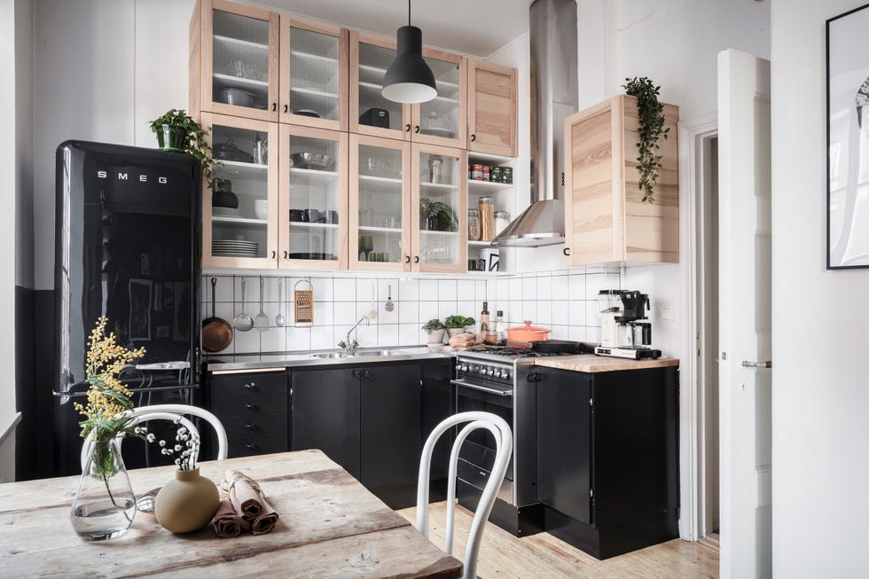 cocina abierta con office de estilo nórdico decorada en blanco con electrodomésticos y armarios de color negro