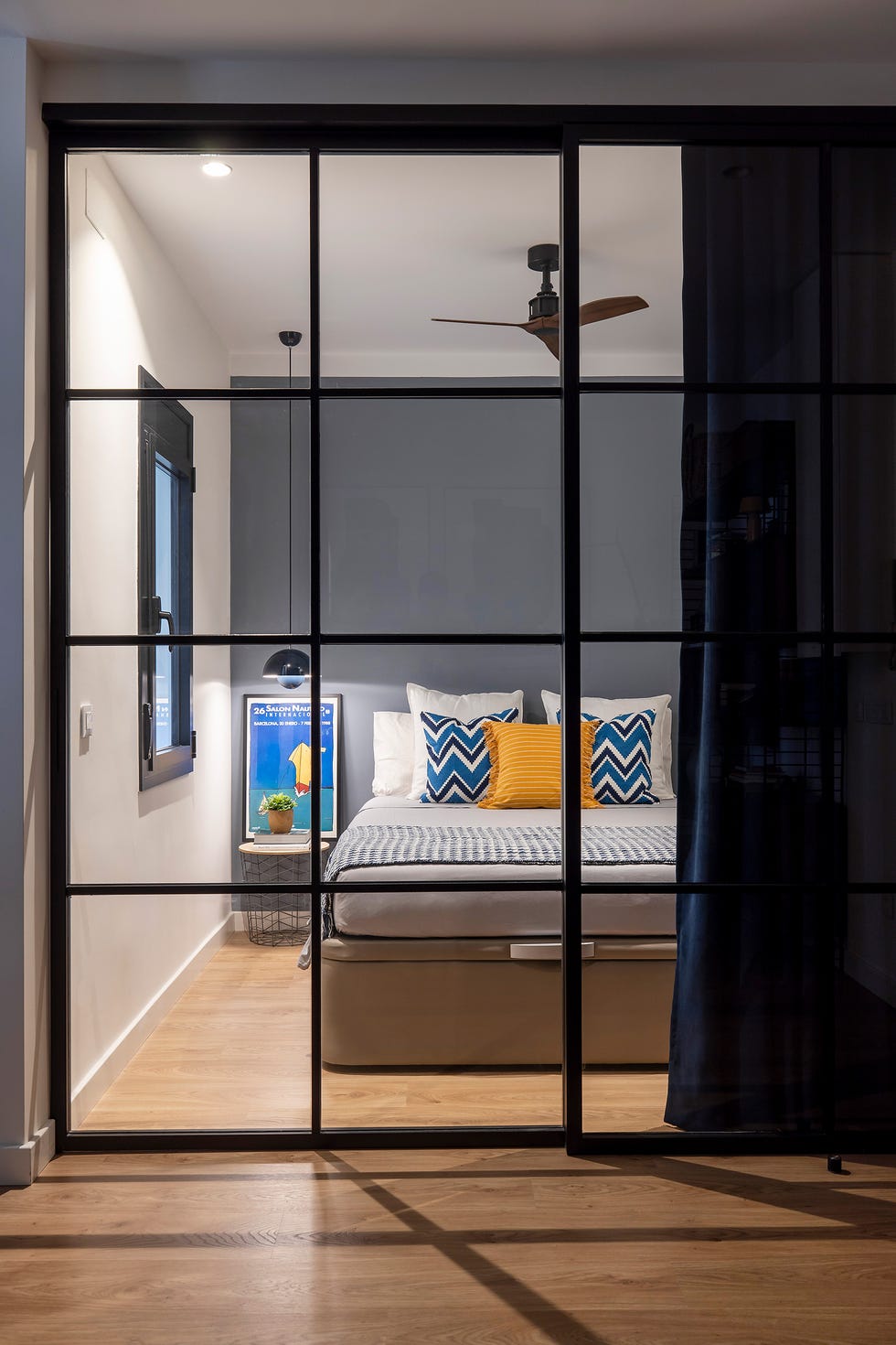 dormitorio con corredera de cristal y perfilería metálica negra