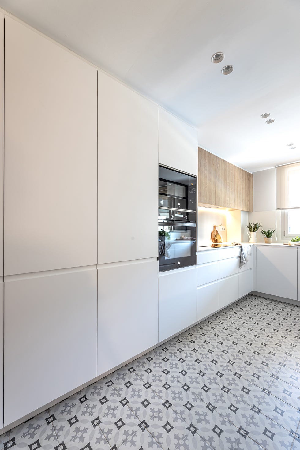 cocina moderna con armarios blancos y suelo de baldosa hidráulica