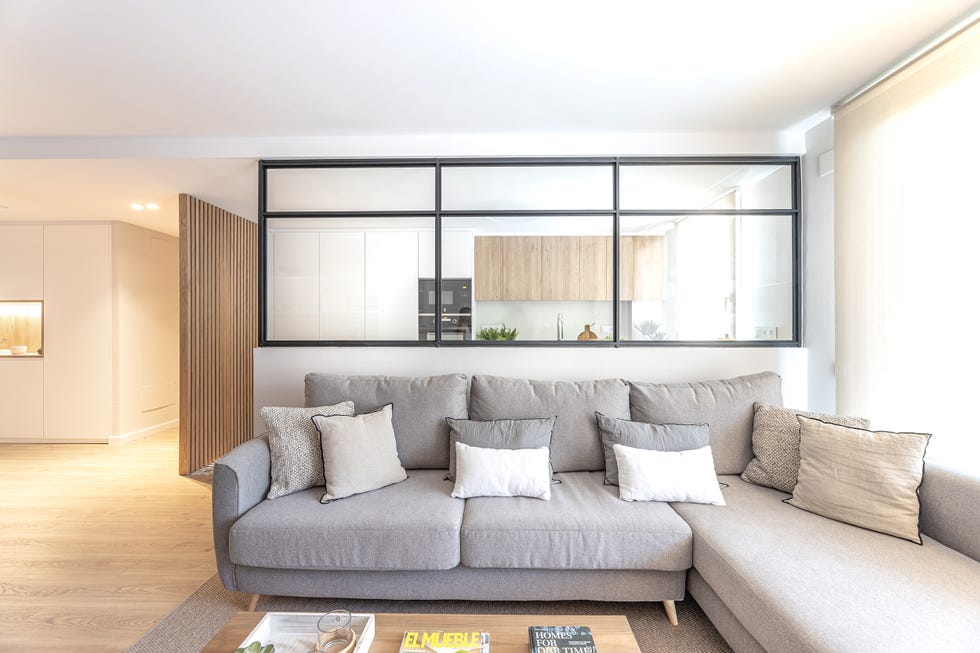 salón abierto a la cocina con sofá con chaise longue gris