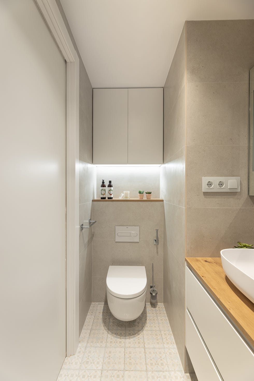 baño moderno con mueble de lavabo suspendido y azulejos cerámicos grises