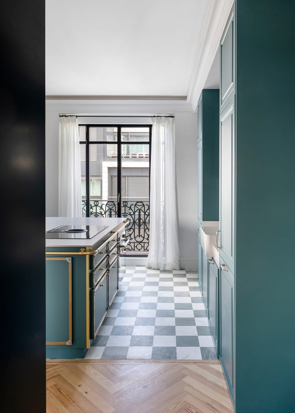 cocina con isla, frentes azules y detalles de latón