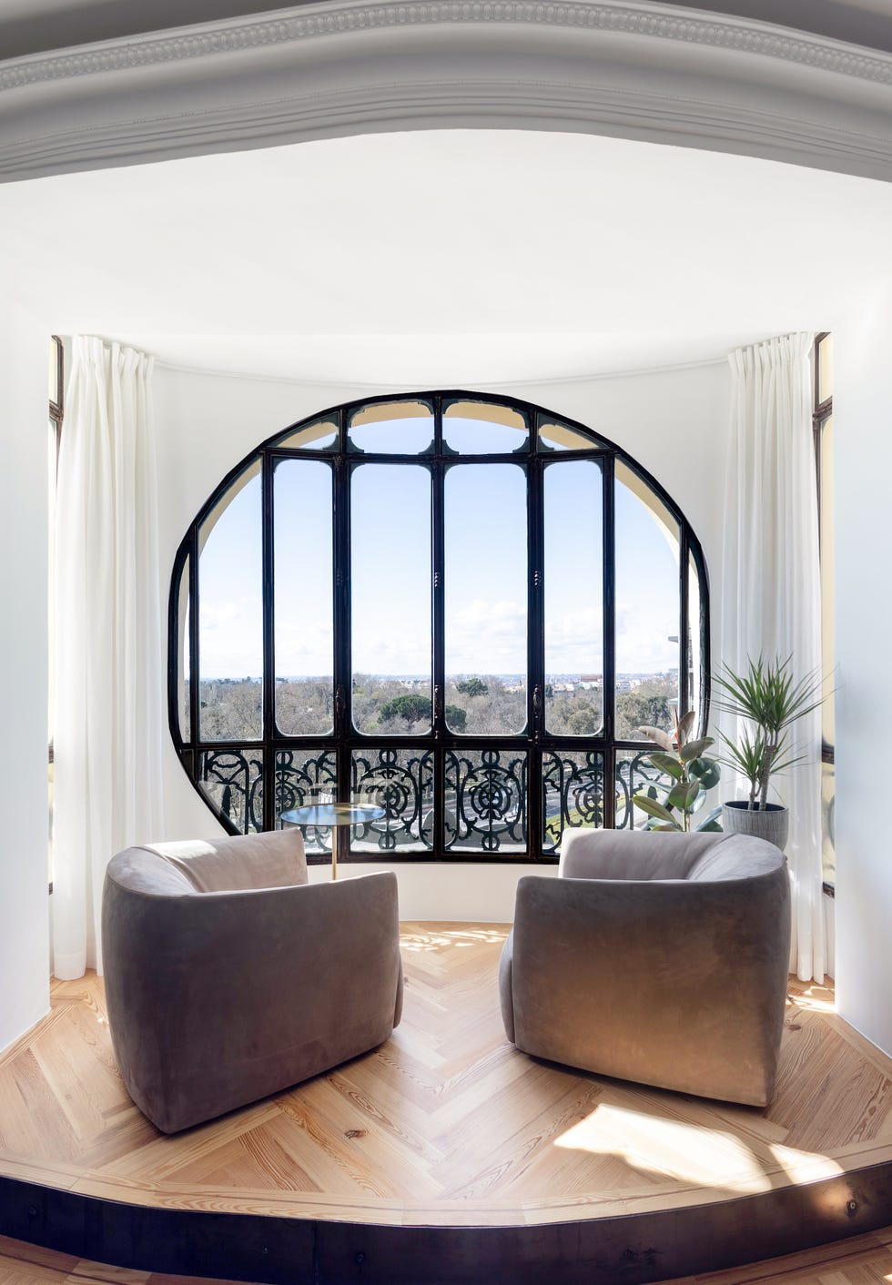 ventana redonda con dos butacas de terciopelo