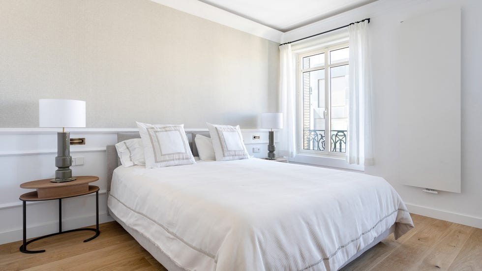 dormitorio clásico moderno con arrimadero blanco y mesita de madera de diseño
