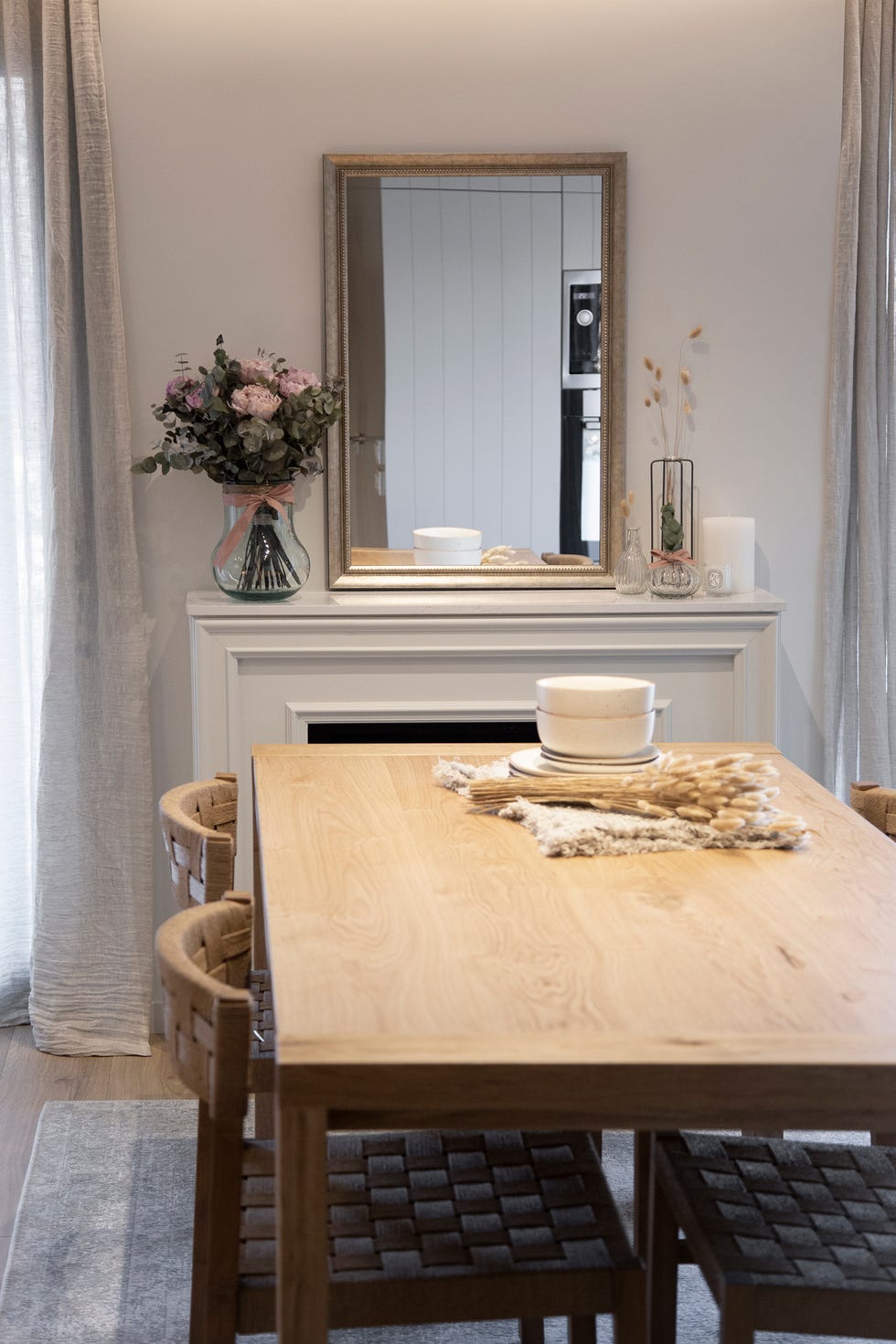 mesa de comedor de madera frente a chimenea con marco blanco