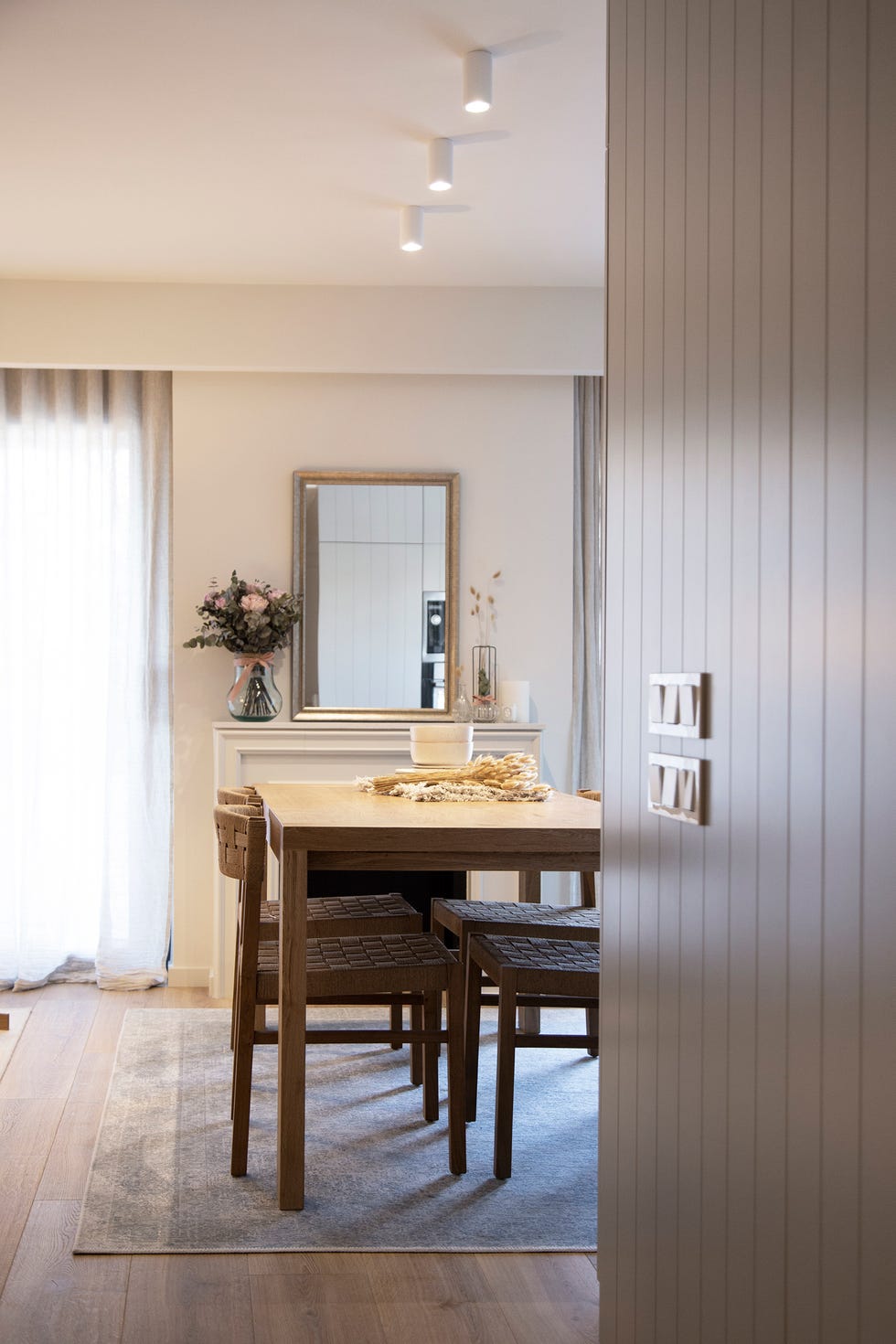 mesa de comedor de madera frente a chimenea con marco blanco