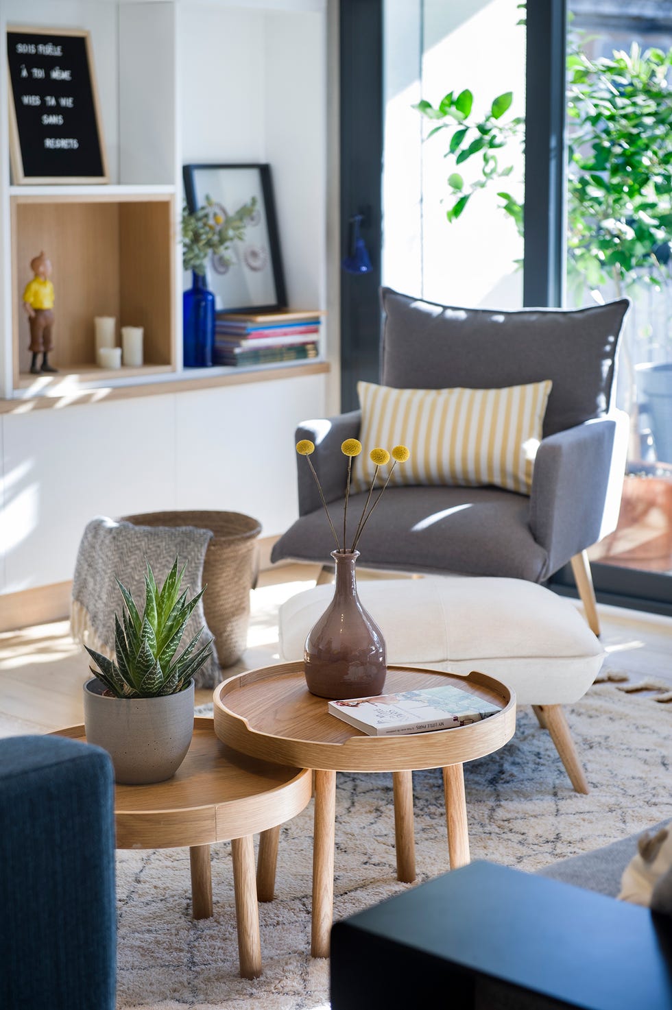 Rincón de lectura con sillón, reposapiés y dos mesas de centro