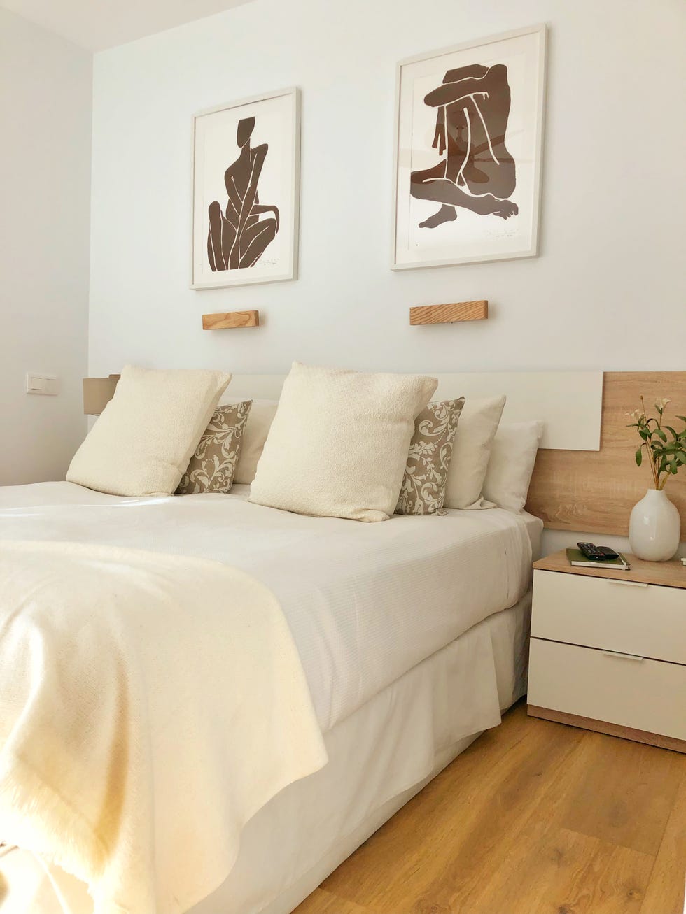 dormitorio de estilo boho con cabecero de madera y mesitas en blanco y madera